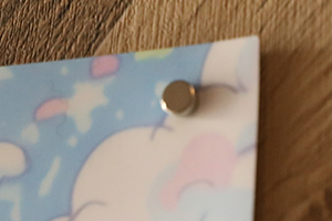 ポスターの右上を丸形超強力マグネットで止めている様子