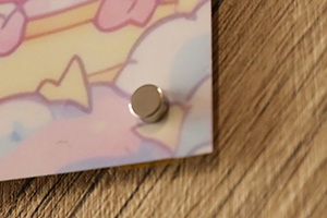 ポスターの右下を丸形超強力マグネットで止めている様子