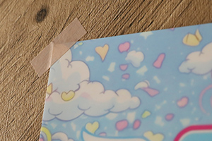 ポスターの左上をマスキングテープで止めている様子