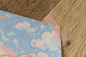 ポスターの右上をマスキングテープで止めている様子