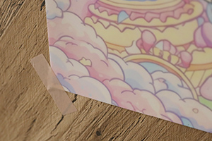 ポスターの左下をマスキングテープで止めている様子