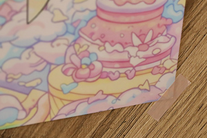 ポスターの右下をマスキングテープで止めている様子