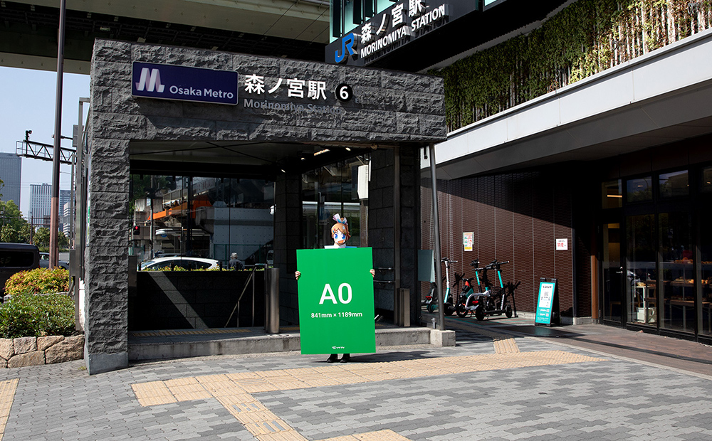 JR森ノ宮駅前でA0サイズの発泡パネルを手にして立っているソクプリ子ちゃん