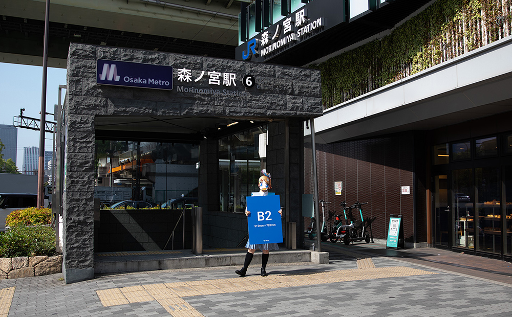 JR森ノ宮駅前でB2サイズの発泡パネルを手にして立っているソクプリ子ちゃん